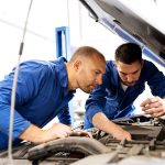 mechanic men with wrench repairing car at workshop