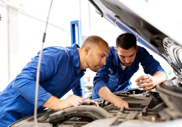 mechanic men with wrench repairing car at workshop