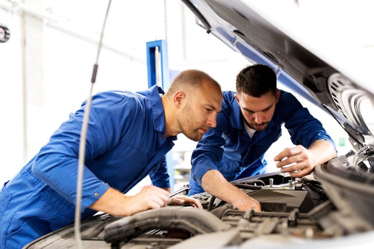 mechanic men with wrench repairing car at workshop